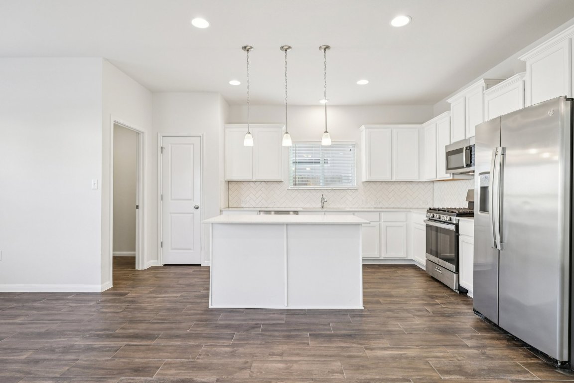 10712 Blacket Drive Austin, TX 78747 - Photo 11 of 40 a kitchen with kitchen island a white counter top space stainless steel appliances and cabinets