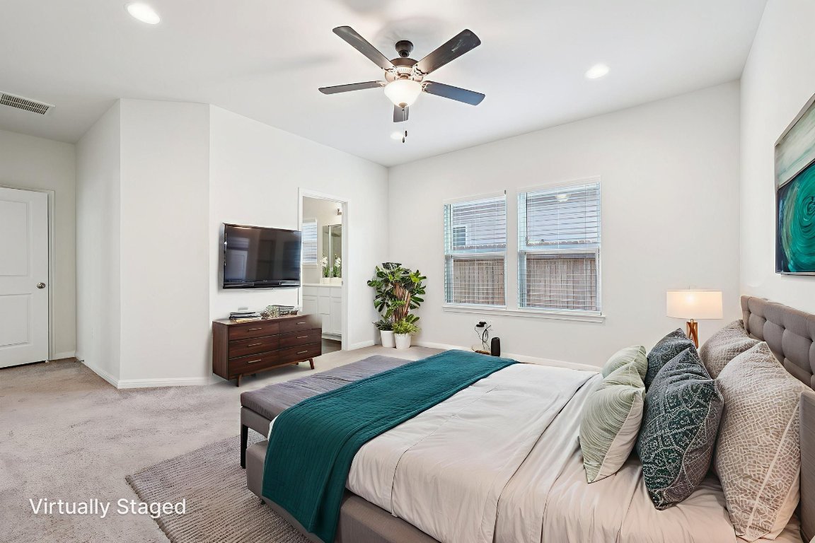 10712 Blacket Drive Austin, TX 78747 - Photo 17 of 40 a bedroom with a large bed and a flat screen tv