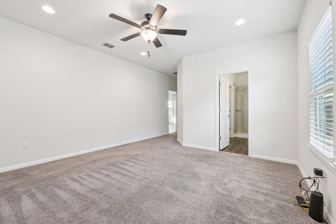 10712 Blacket Drive Austin, TX 78747 - Photo 19 of 40 an empty room with windows and fan