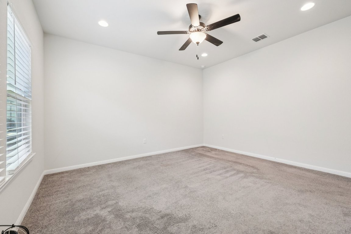 10712 Blacket Drive Austin, TX 78747 - Photo 20 of 40 an empty room with a window and a ceiling fan