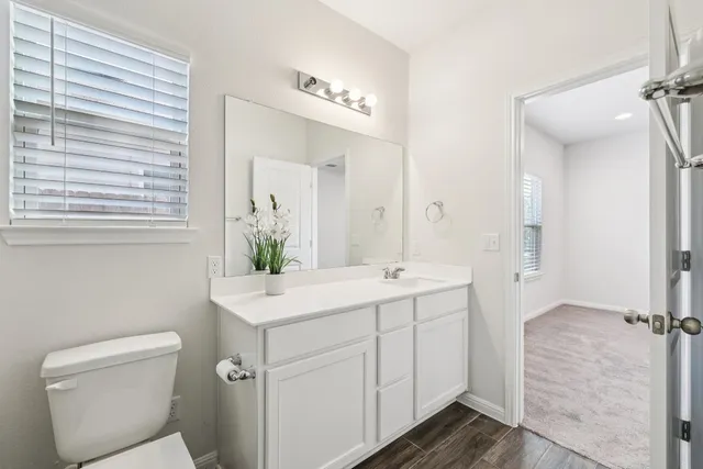 a spacious bathroom with a double vanity sink toilet mirror and a shower
