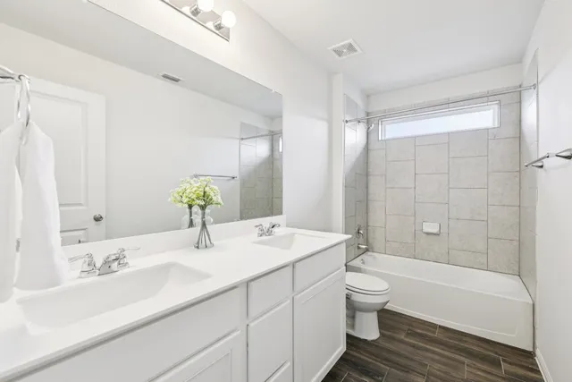 a bathroom with a granite countertop sink a toilet and bathtub