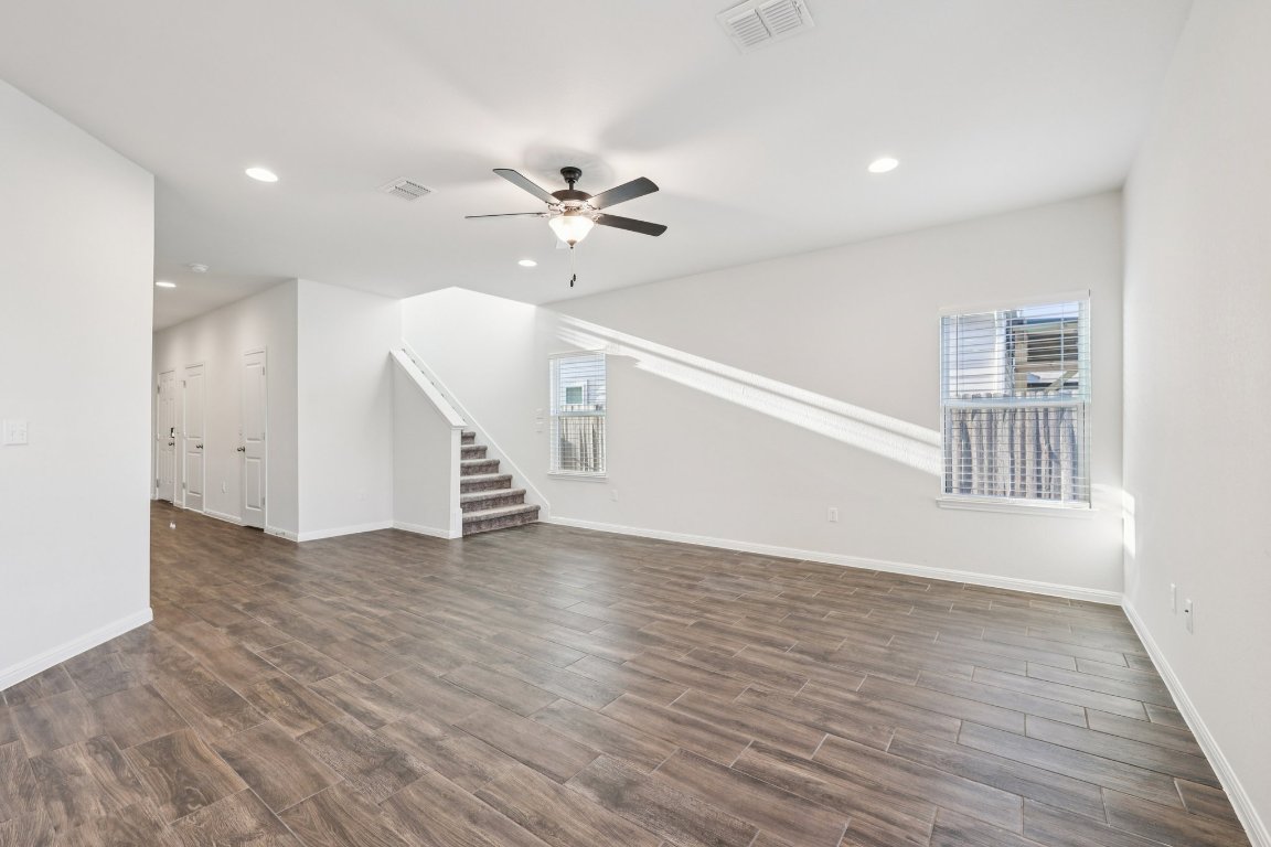 10712 Blacket Drive Austin, TX 78747 - Photo 4 of 40 a view of an empty room with wooden floor and a ceiling fan