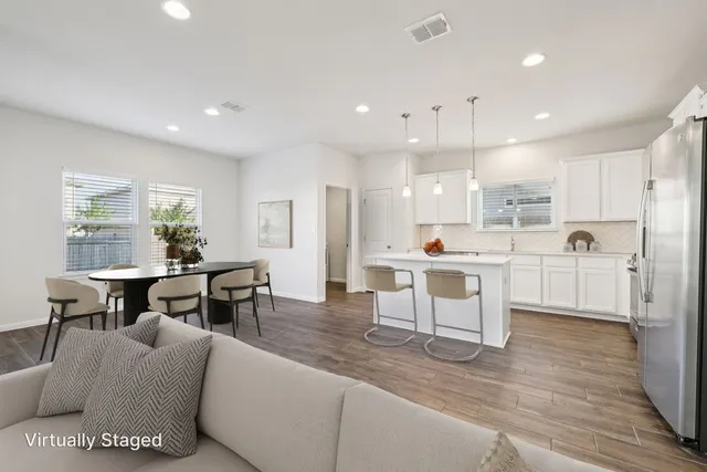 a living room with stainless steel appliances kitchen island granite countertop furniture and a dining table with kitchen view