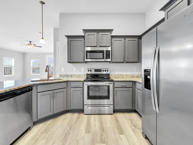 a kitchen with a refrigerator and a stove top oven