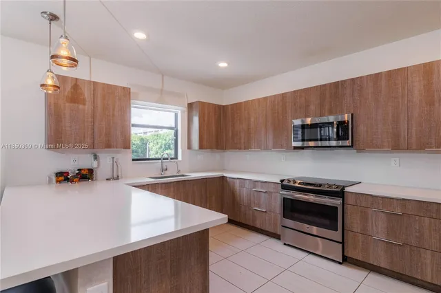 a kitchen with a sink a stove and cabinets