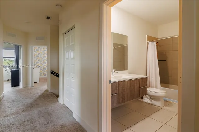 a spacious bedroom with a bed and a lamp