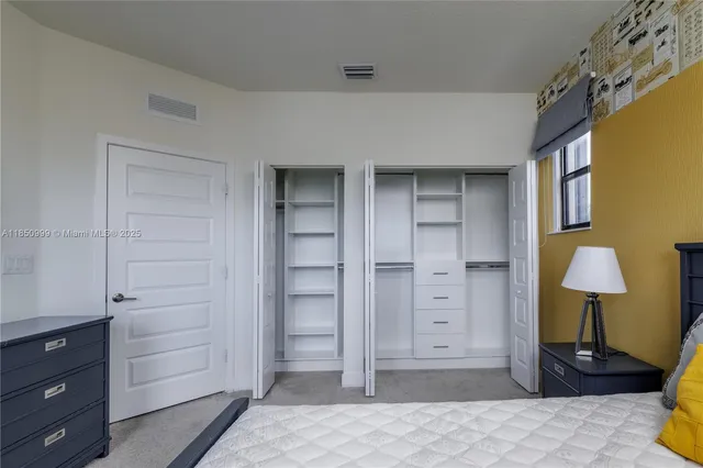 a view of walk in closet with empty racks