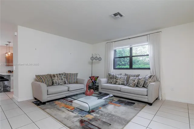 a dining room with wooden floor a chandelier a wooden table and chairs