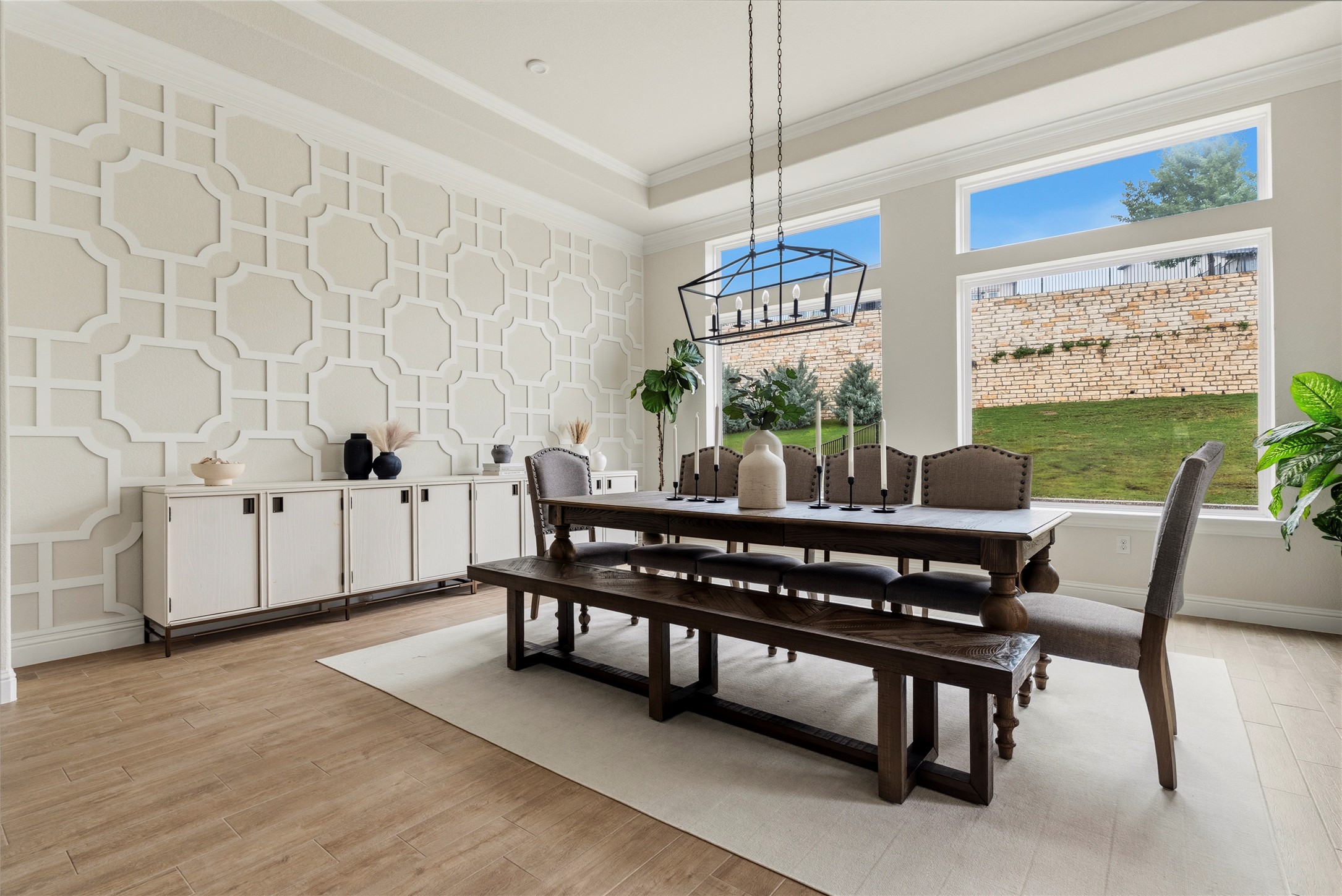 4513 Vieste View Leander, TX 78641 - Photo 21 of 40 Dining area featuring a prominent accent wall with geometric paneling, wood-finish flooring, and crown molding