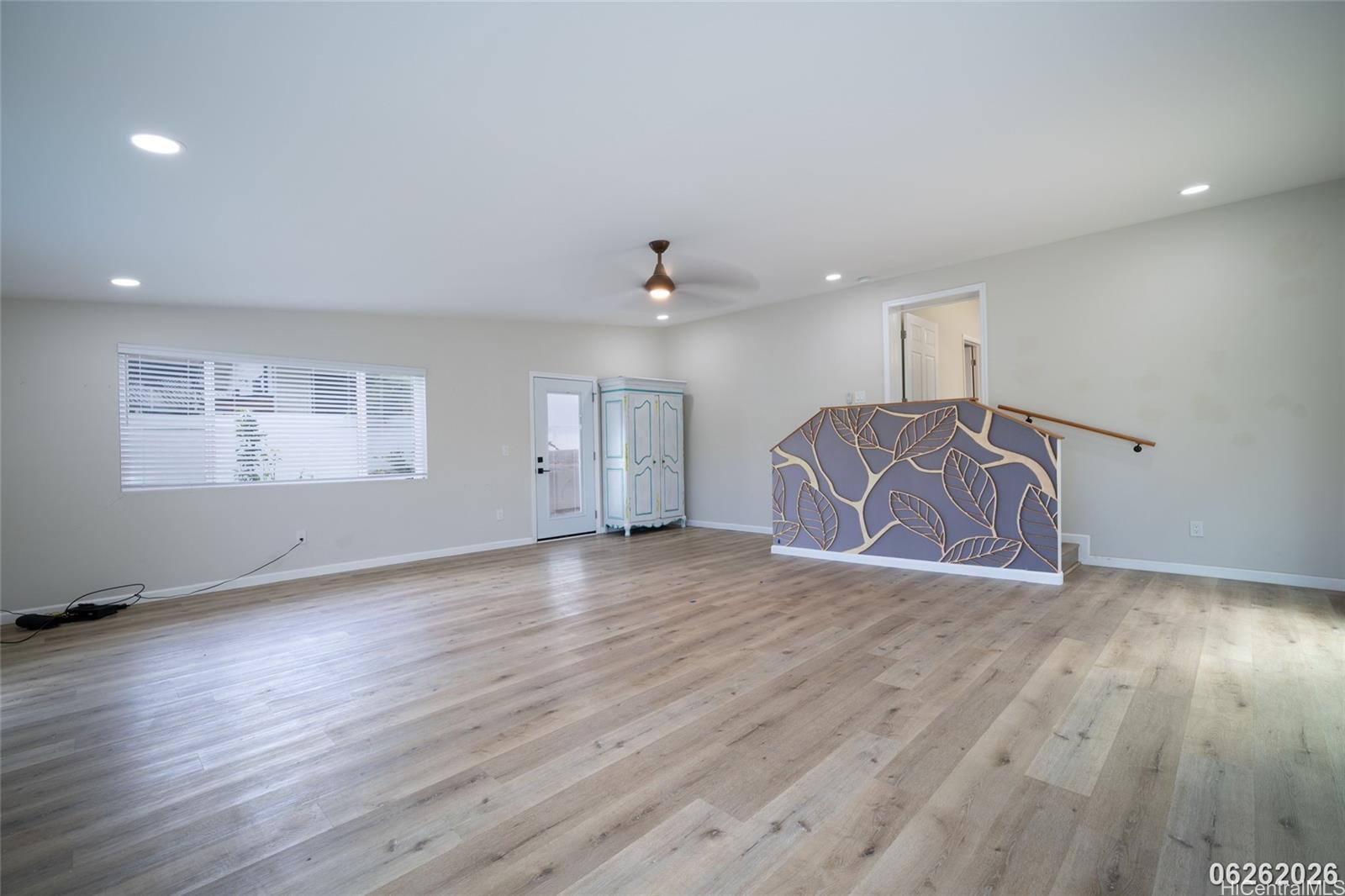 87-1409 Akowai Road Waianae, HI 96792 - Photo 20 of 25 a view of an empty room with wooden floor and a window