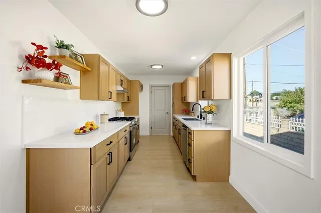 a kitchen with a sink and wooden floor