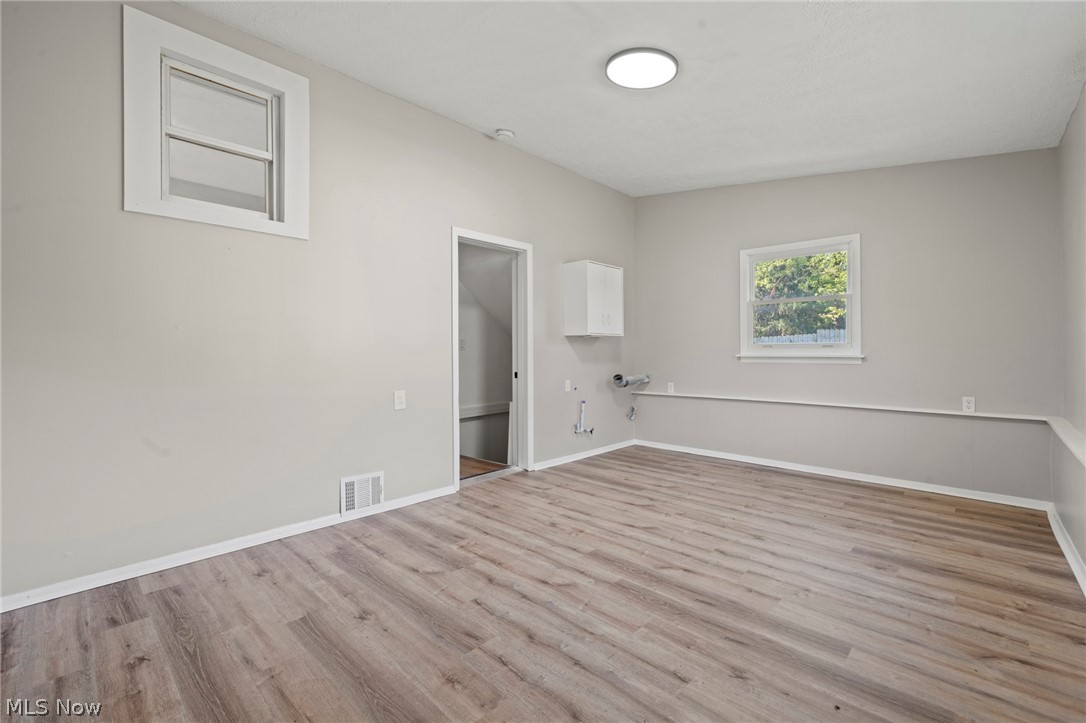 1218 Briggle Road Akron, OH 44320 - Photo 24 of 40 Spacious room featuring wood-finish flooring, light gray walls, and white trim