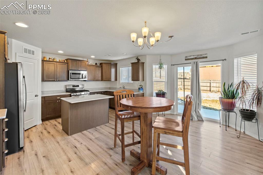 8151 Berwyn Loop Peyton, CO 80831 - Photo 11 of 39 a kitchen with a table chairs refrigerator and dining table
