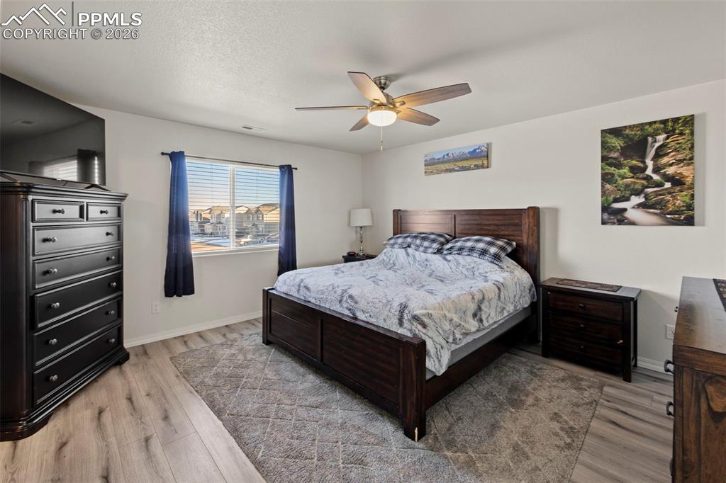 8151 Berwyn Loop Peyton, CO 80831 - Photo 22 of 39 a bedroom with a bed and a flat screen tv