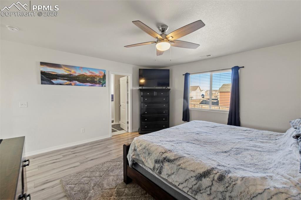 8151 Berwyn Loop Peyton, CO 80831 - Photo 23 of 39 a bedroom with a large bed and a chandelier