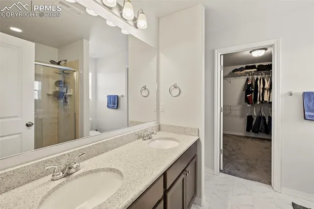 a bathroom with a granite countertop sink a mirror and a shower