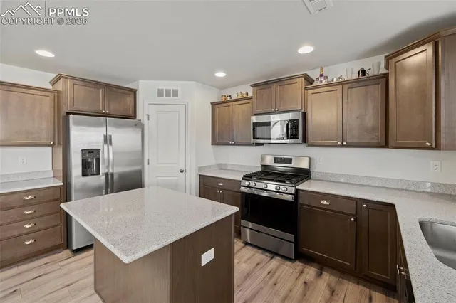 a kitchen with stainless steel appliances and wooden cabinets