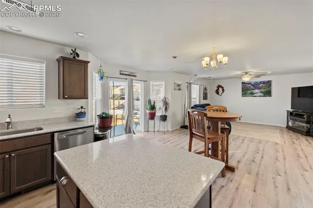 a living room with furniture and a dining table with wooden floor