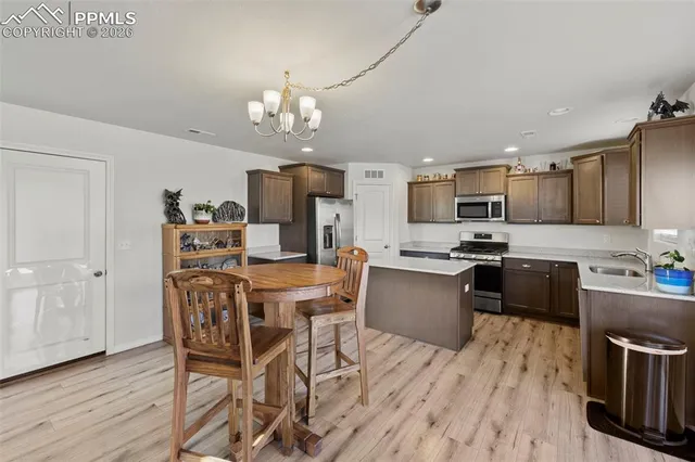 a kitchen with a table chairs microwave and cabinets