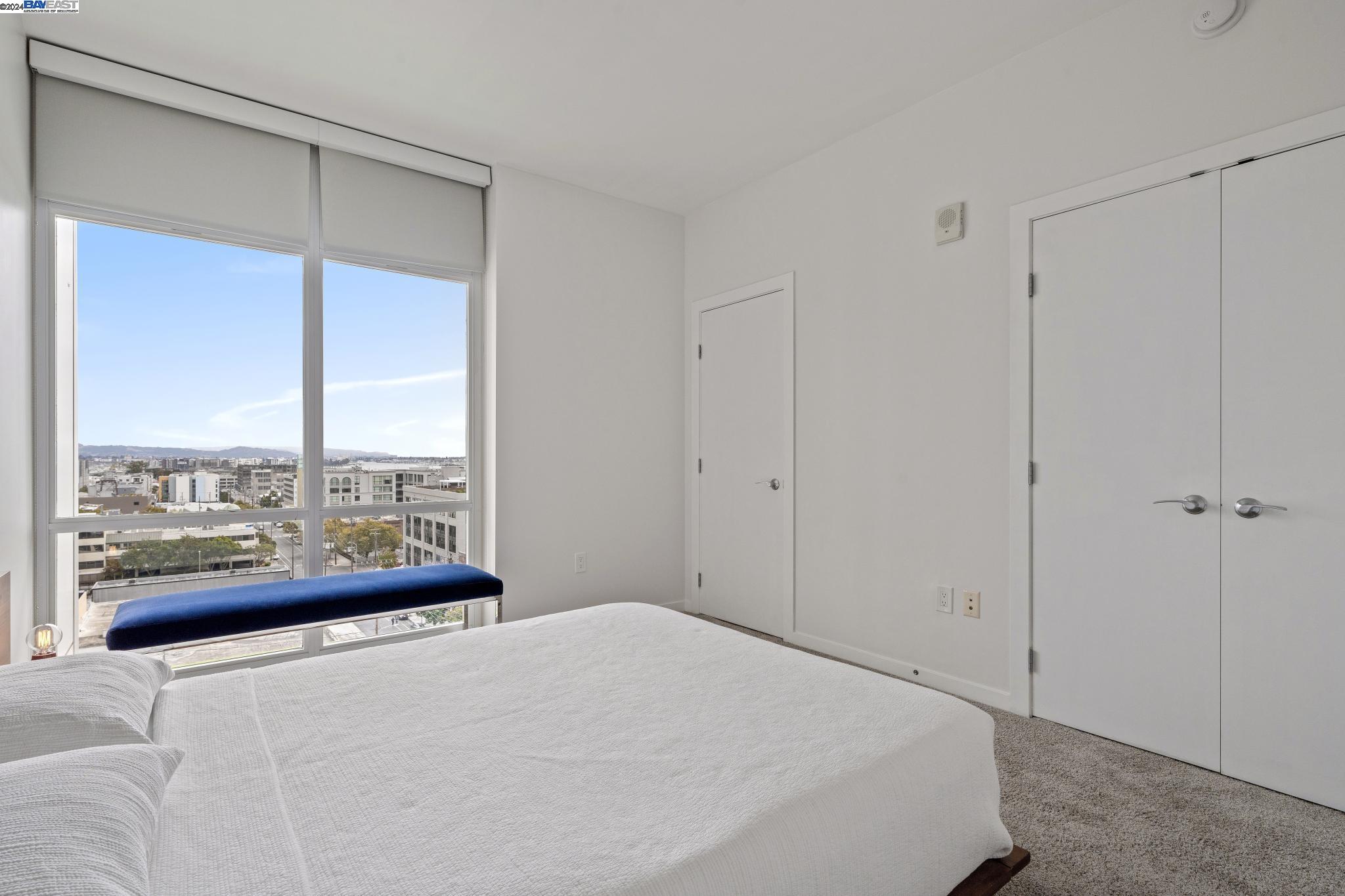222 Broadway, Unit 1106 Oakland, CA 94607 - Photo 3 of 22 a bedroom with a large window and a balcony