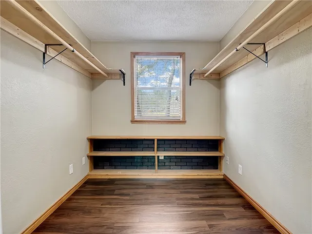 a view of a room with wooden floor and a window