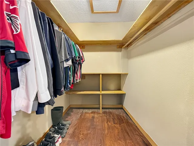 a view of walk in closet with clothes and shoes