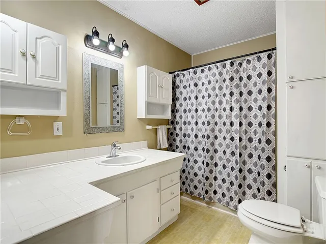 a bathroom with a sink a toilet a shower and a mirror