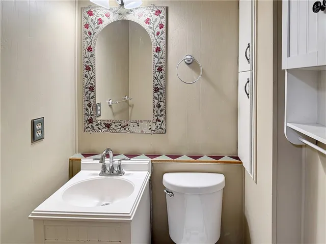 a bathroom with a sink and mirror with toilet