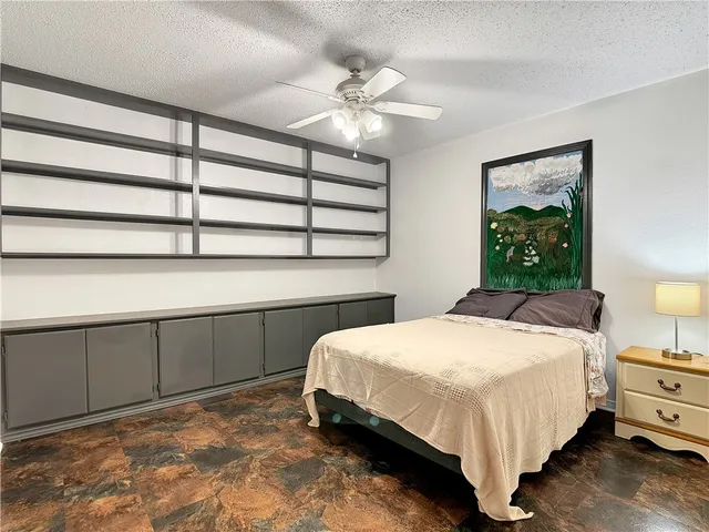 an empty room with wooden floor and chandelier fan