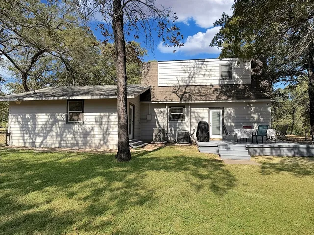 a view of a house with yard and sitting area