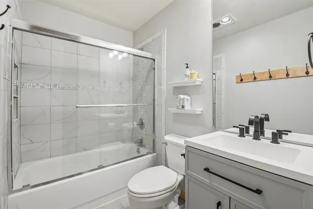 a bathroom with a sink a toilet and shower