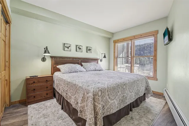 a bedroom with a bed and a dresser next to a window