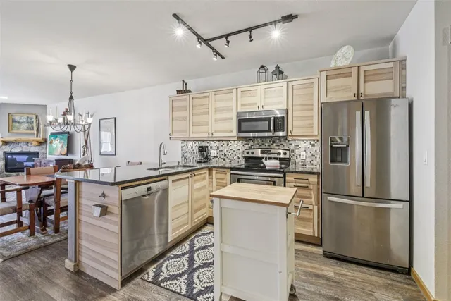 a kitchen with kitchen island white cabinets and stainless steel appliances