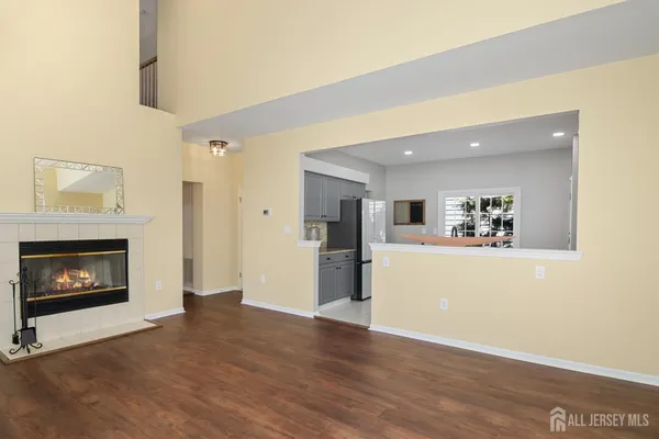 a view of a livingroom with wooden floor and a fireplace