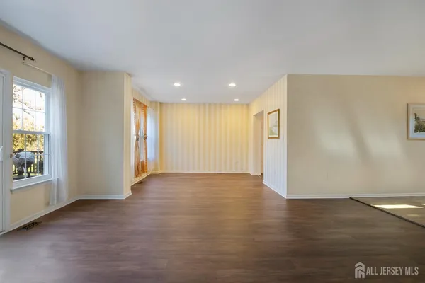 a view of empty room with a fireplace and wooden floor