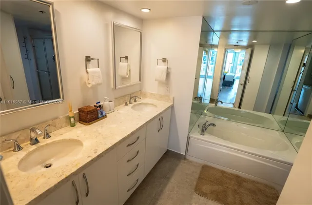 a bathroom with a tub sink and mirror