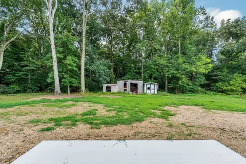 a front view of house with yard and trees around