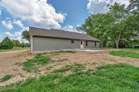 a view of a house with backyard and a garden