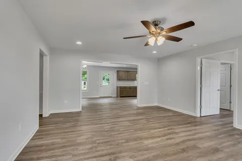 a view of an empty room and window and wooden floor