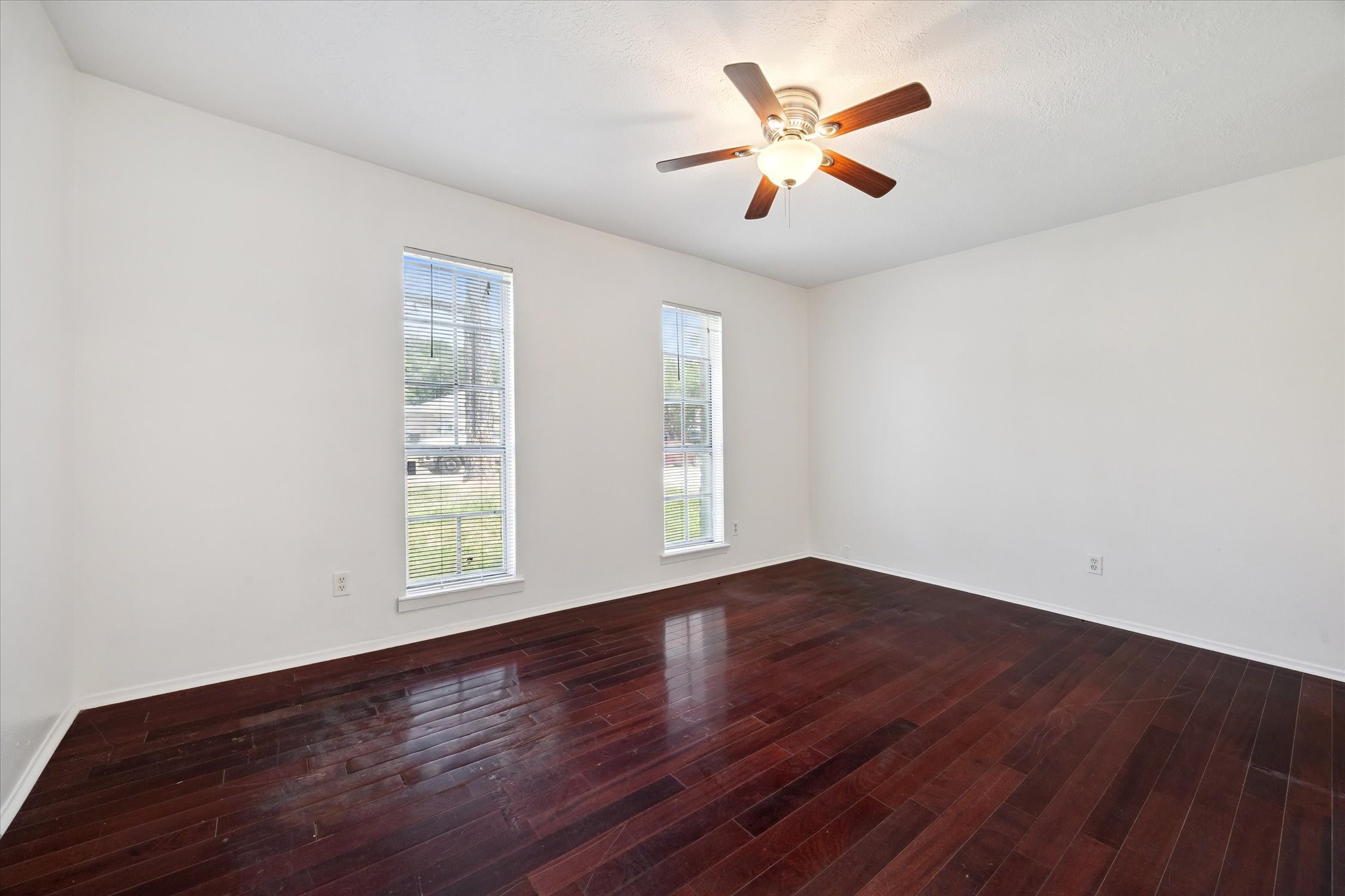 4731 Brookston Street Houston, TX 77045 - Photo 7 of 13 an empty room with wooden floor and windows