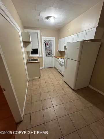 a kitchen with granite countertop a refrigerator and a stove top oven