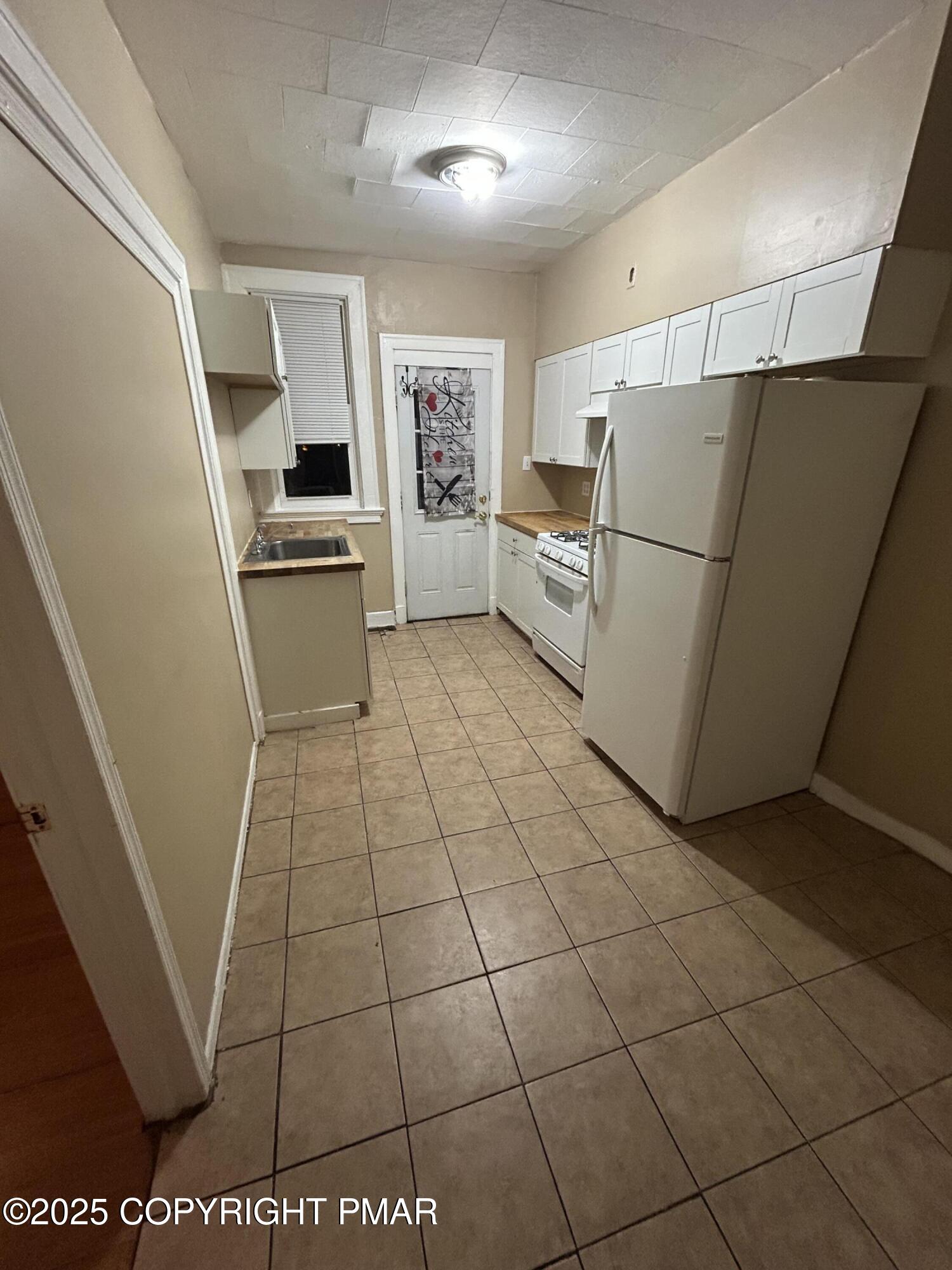 296 Washington Street, Unit 3B East Stroudsburg, PA 18301 - Photo 3 of 5 a kitchen with granite countertop a refrigerator and a stove top oven