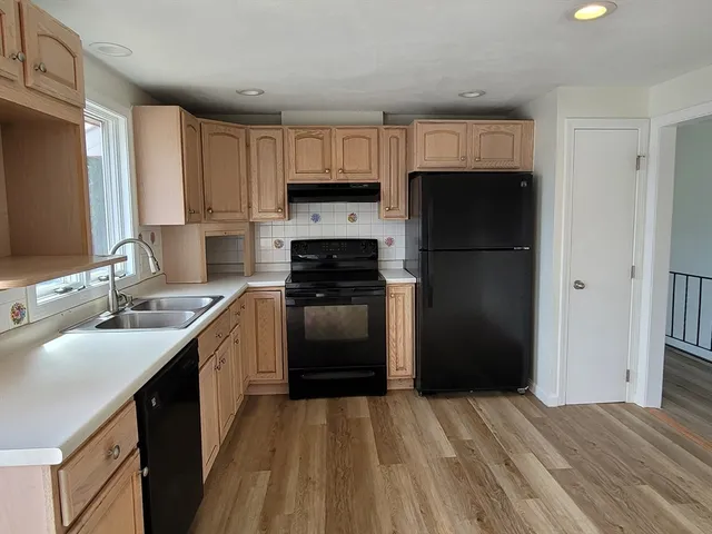 a kitchen with a refrigerator sink and cabinets