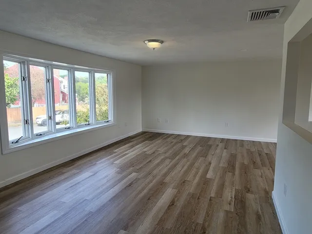 wooden floor in an empty room with a window