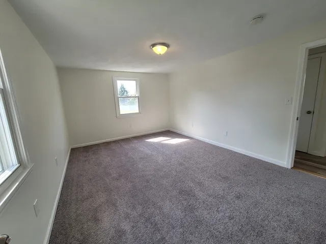an empty room with a window and a ceiling fan