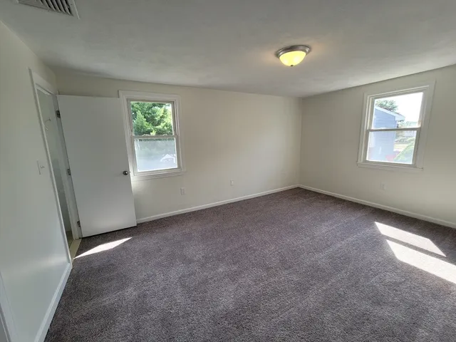 an empty room with windows and closet