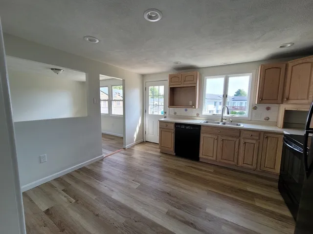 a large kitchen with a stove a sink dishwasher and a refrigerator