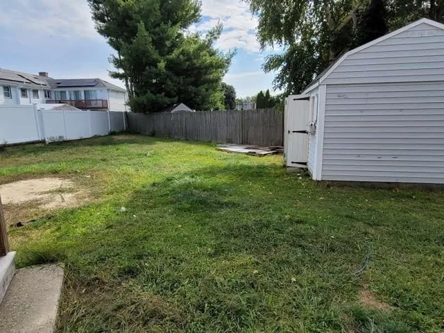 a view of a house with a big yard potted plants and large tree