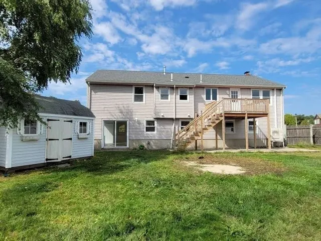 a view of a house with a big yard and large trees